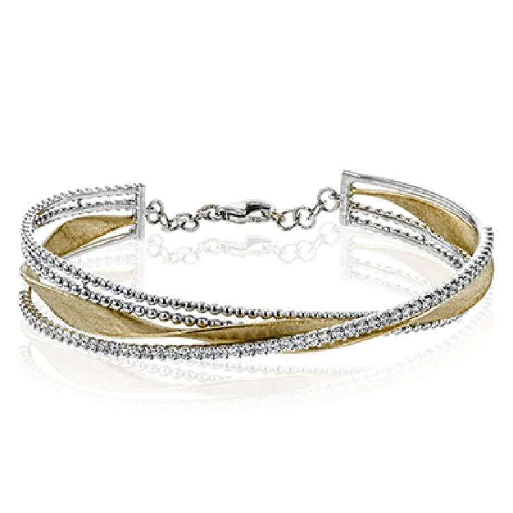 Women’s chic bracelets-This eye catching bangle features a ribbon of yellow gold with brushed matte finish, framed with a double line of white gold beading and an asymetric line of diamonds 0.90 ctw.