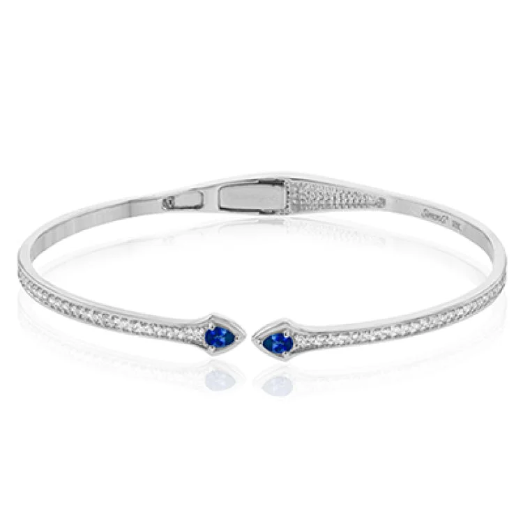 Women’s charm bracelets-This modern hinged bangle adds a touch of color with two precious gemstone accent, set off by .40 ctw of white diamonds along the sides.