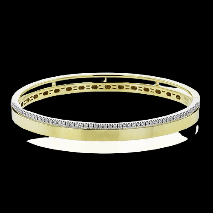 Women’s vintage bracelets-This stunning yellow gold bangle has a matte finish and is accented by a row of white diamonds 0.32 ctw., along its edge.