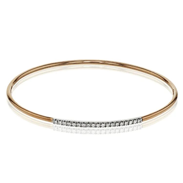 Women’s modern bangles-This lovely 18k rose gold bangle contains .13 ctw of white diamonds in a simple line. This bangle is perfect for stacking, or making a delicate statement all on its own.