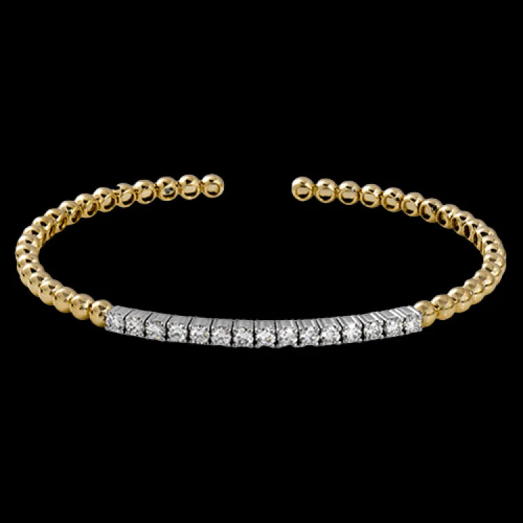 Women’s tennis bracelets-This wonderful bangle showcases a straight line of .97 ctw of white diamonds set within 18k yellow gold beads.