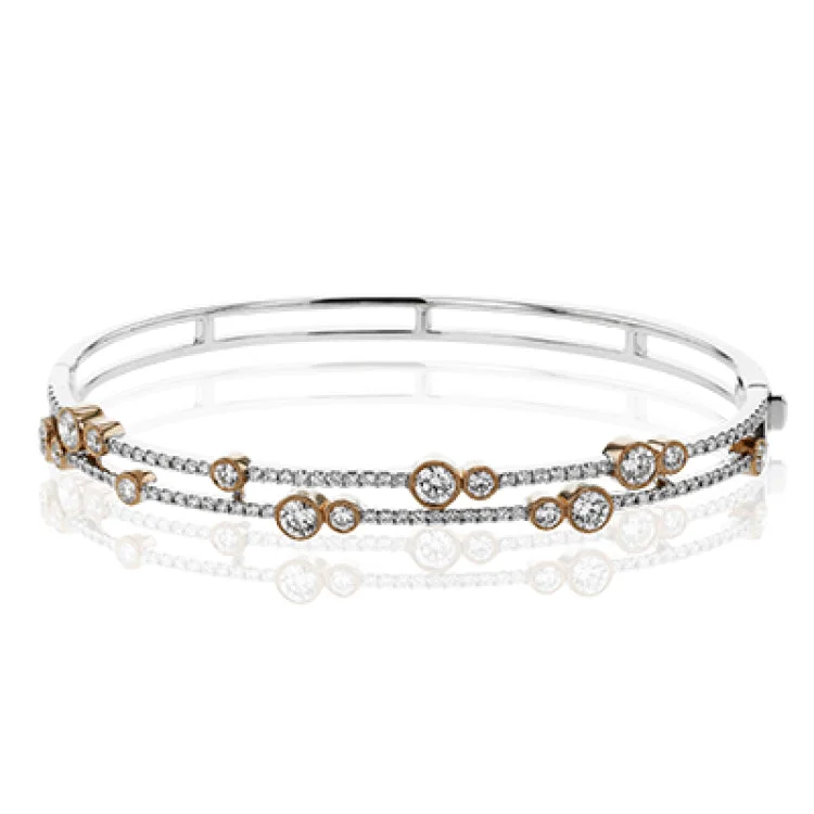 Women’s minimalist bangles-This whimsical bangle in 18K white gold features 1.80 ctw of bezel set diamonds, that appear to be suspended on a wire